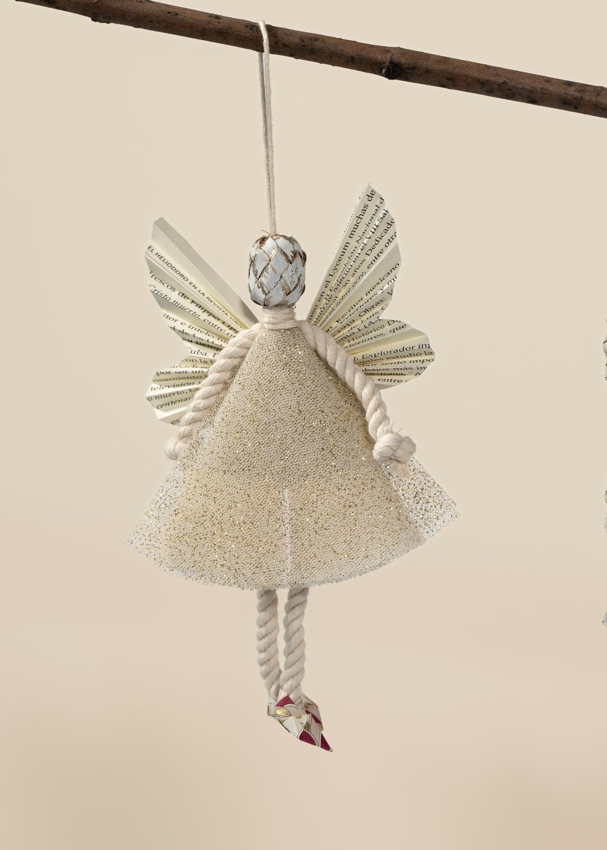 Esfera ángel hada dorada, vestido de tul con brillo dorado, colgada de una rama