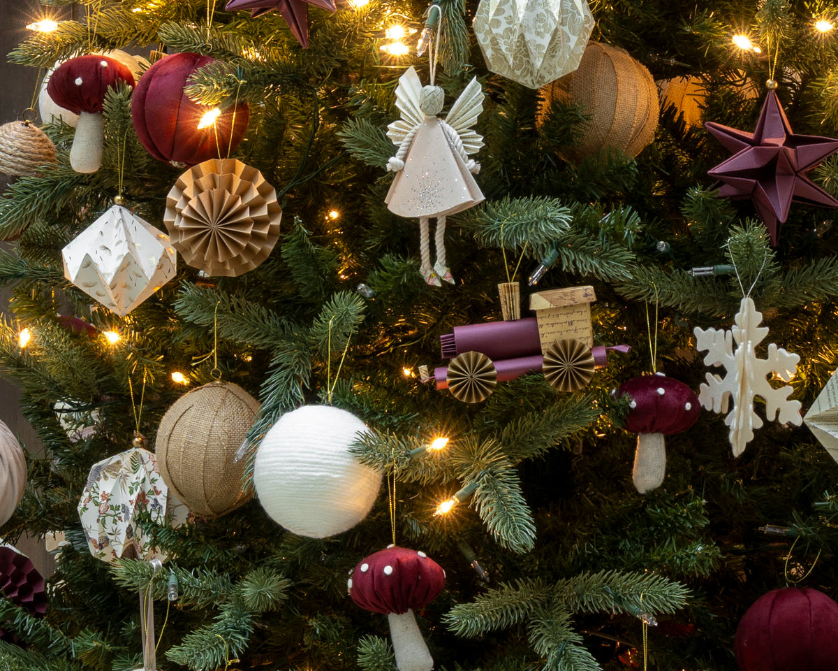 Esfera tren de origami en vino colgada en el árbol de Navidad