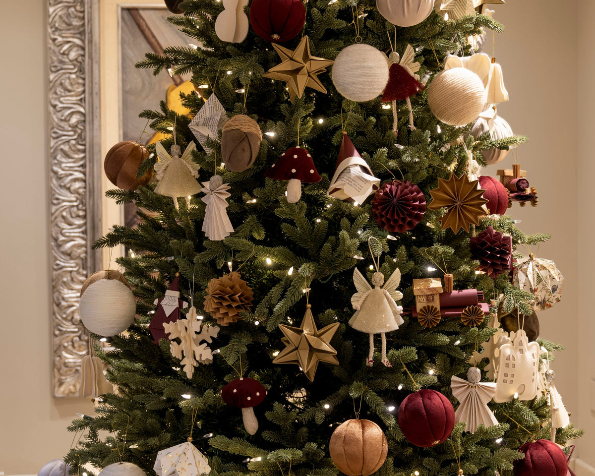 Árbol de Navidad con esferas tren en vino y ángeles hada
