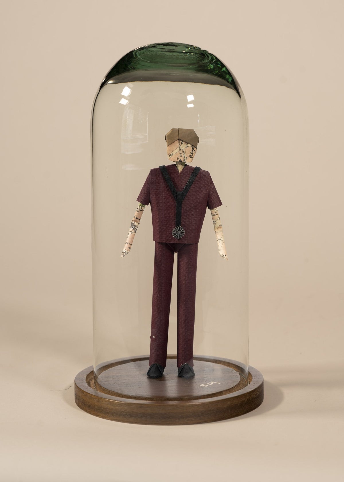 Doctor de origami con scrubs color vino, en capelo de vidrio sobre base de madera