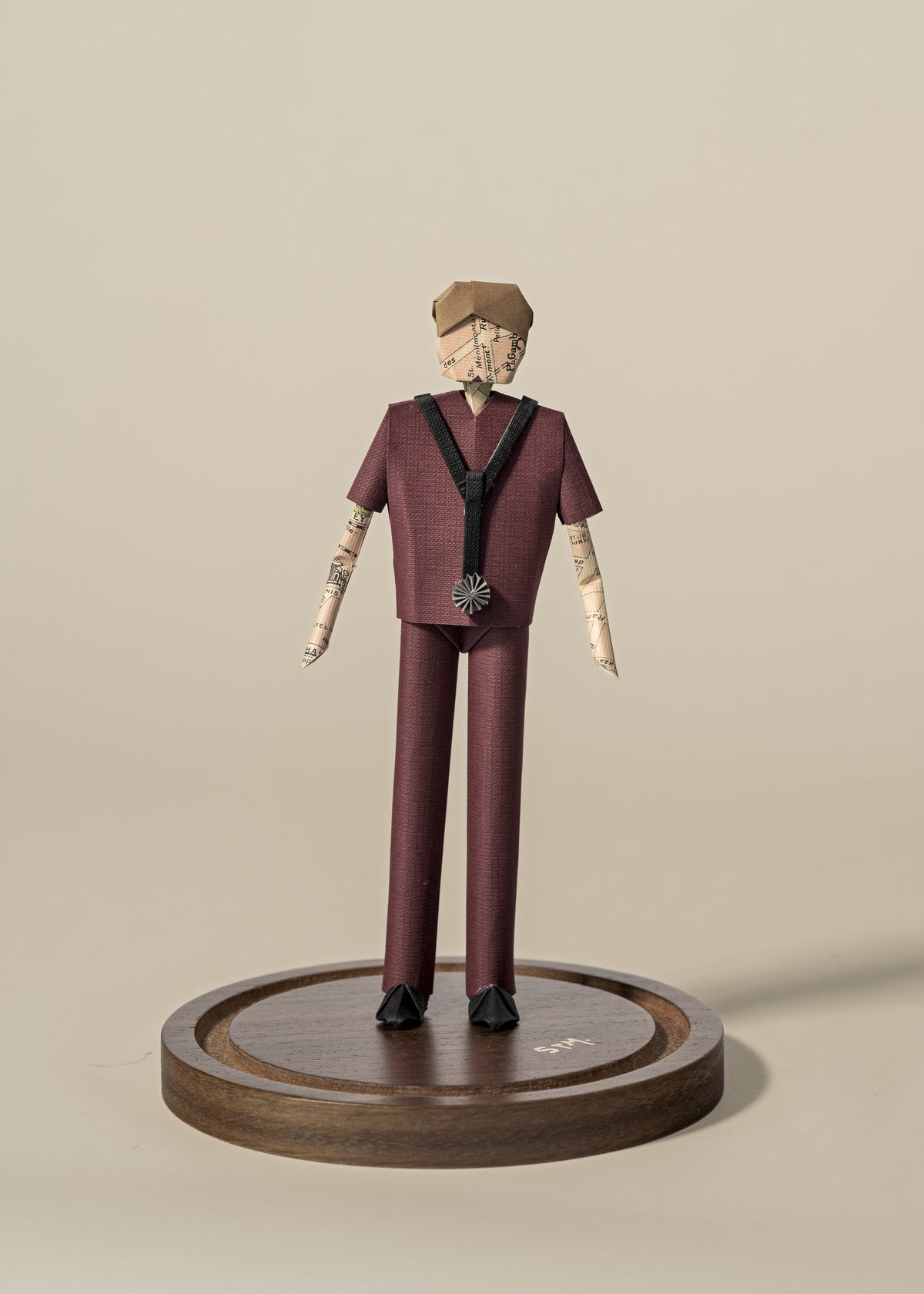 Figura de doctor de origami con scrubs color vino, sobre base de madera