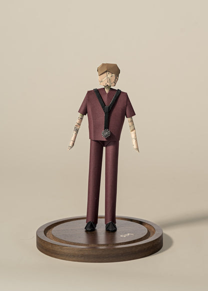 Figura de doctor de origami con scrubs color vino, sobre base de madera