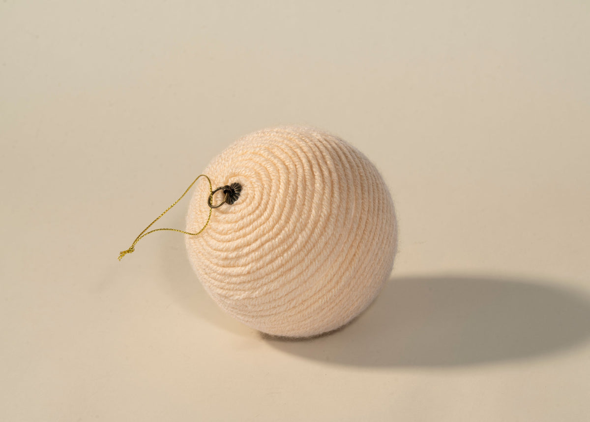 Esfera de estambre beige, detalle del enrollado a mano