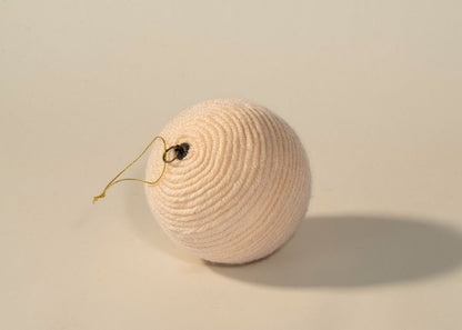 Esfera de estambre beige, detalle del enrollado a mano