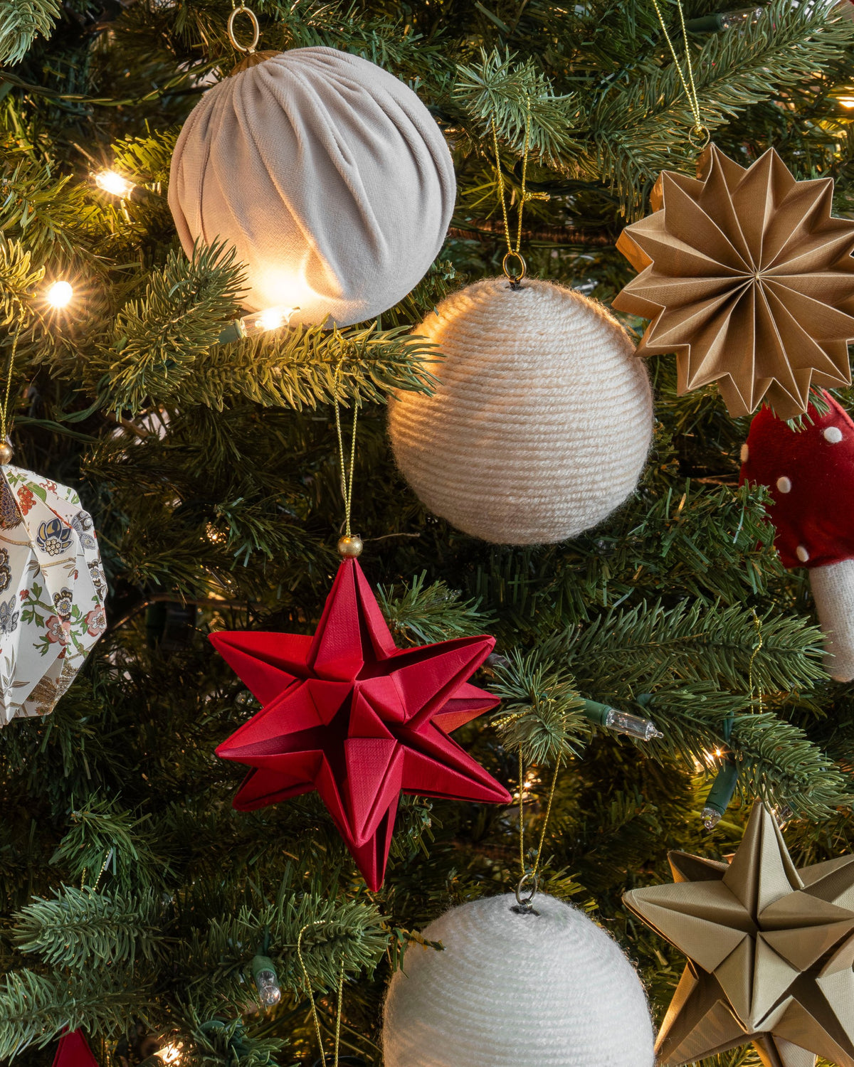 Esferas de estambre beige y hueso en el árbol de Navidad