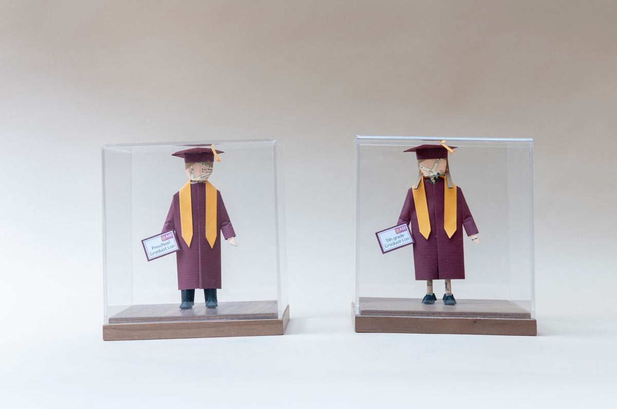 Dos piezas de graduación con toga guinda, kínder y quinto grado, en cajas de acrílico