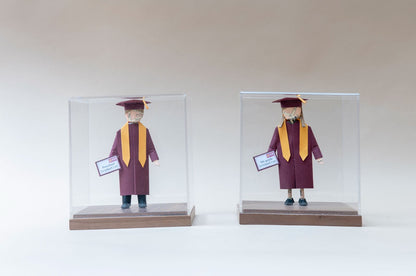 Dos piezas de graduación con toga guinda, kínder y quinto grado, en cajas de acrílico