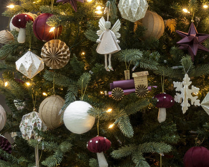 Ángel hada colgada en el árbol de Navidad, entre esferas de papel y lana