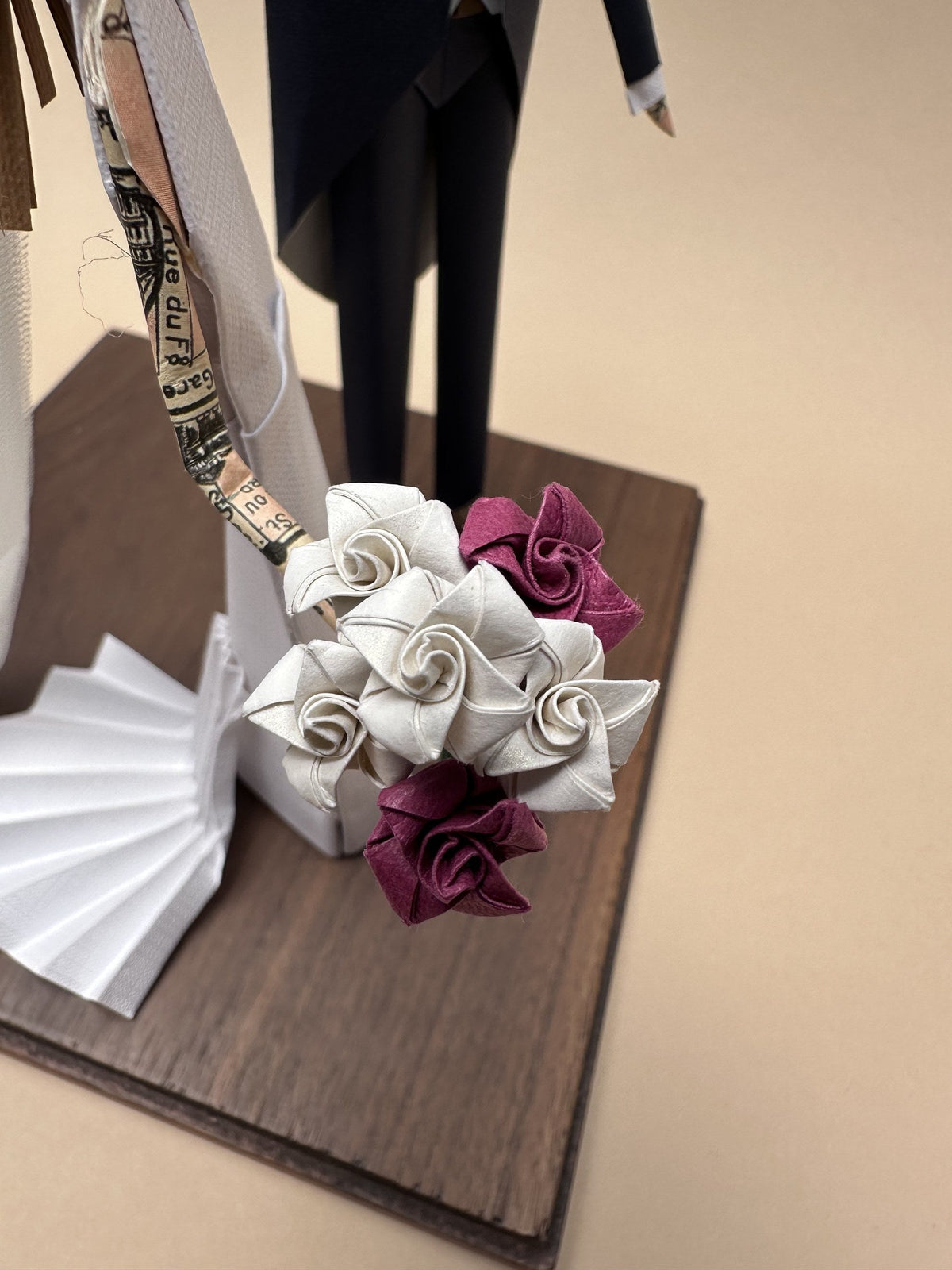 Ramo de rosas de origami en blanco y vino, en la pieza de novios