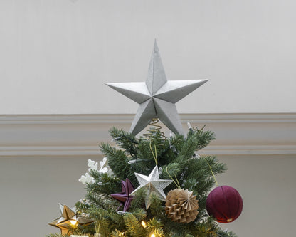 Punta de árbol estrella plateada colocada en la punta de un árbol de Navidad