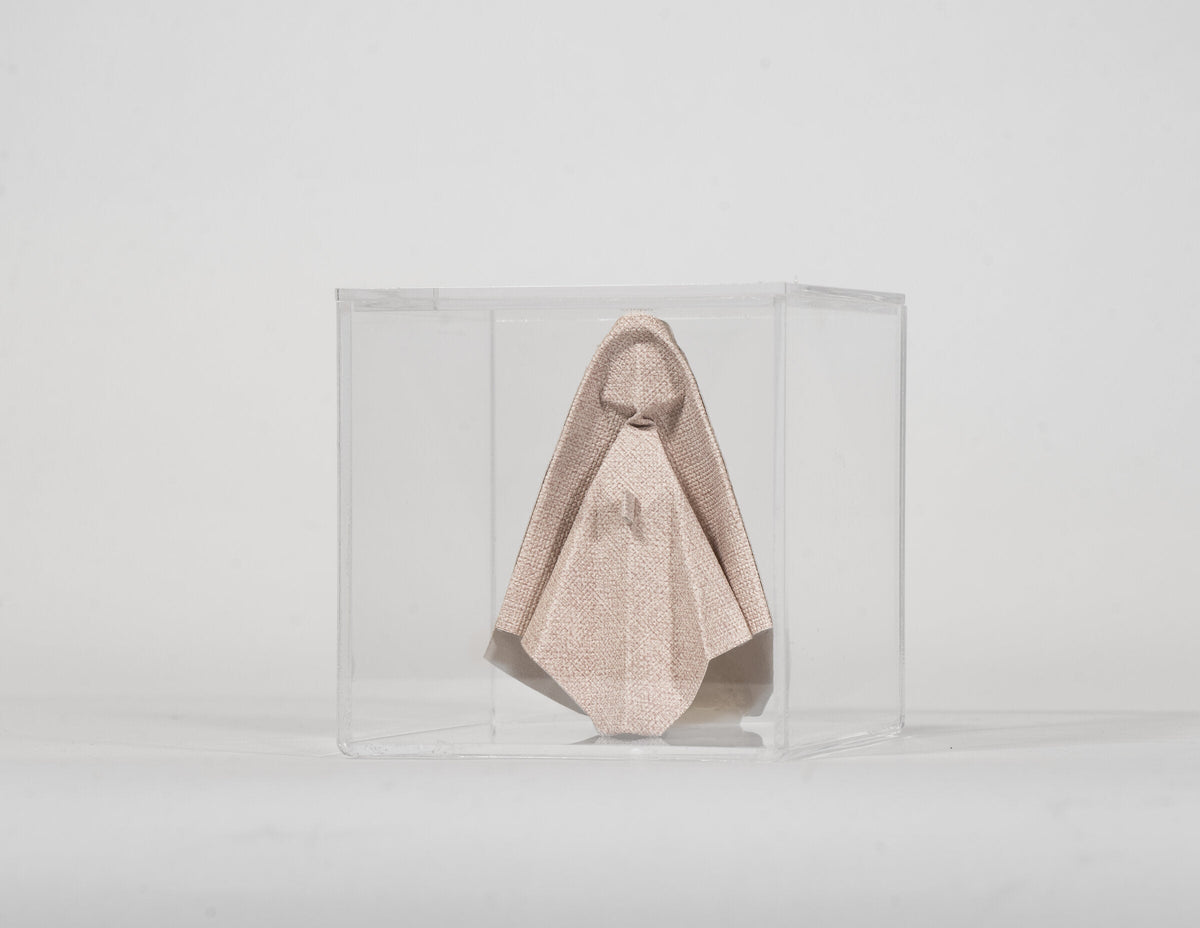 Virgen de origami rosa en caja de acrílico sobre fondo claro